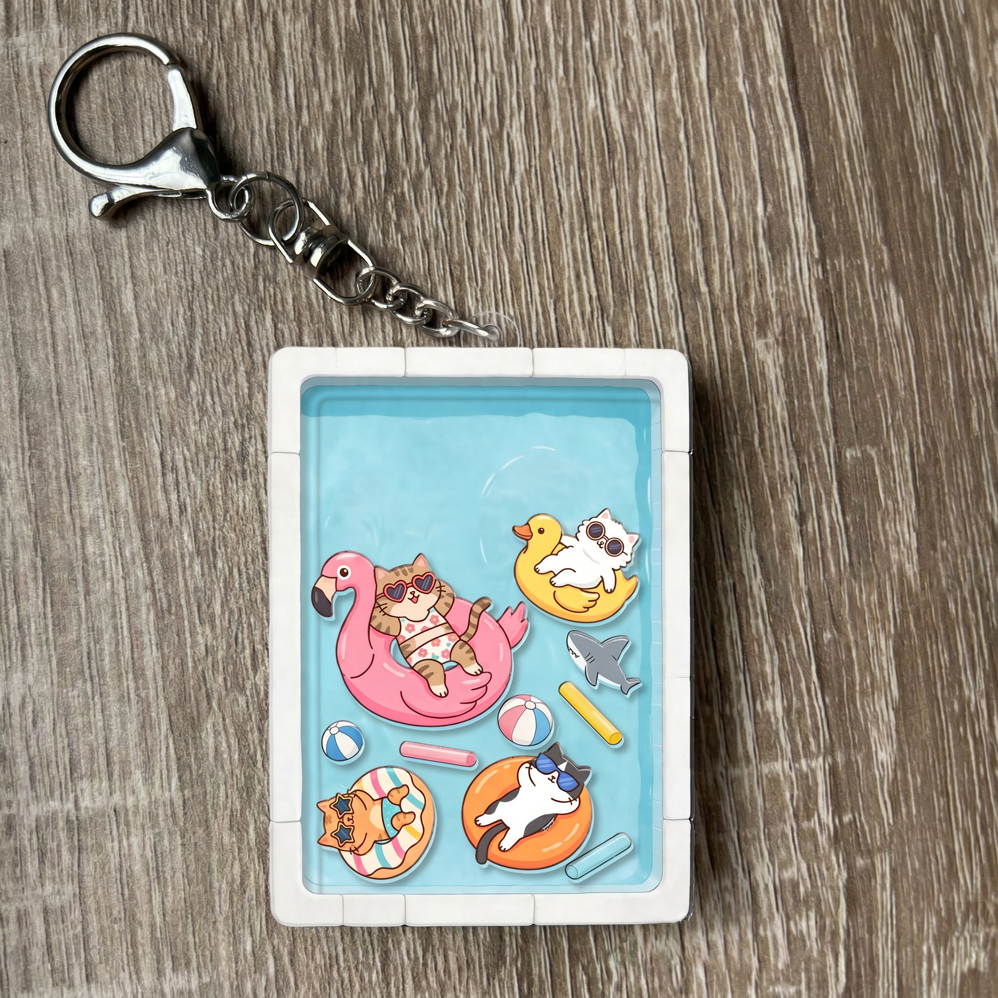 Keychain with cat pool party characters on a wooden surface
