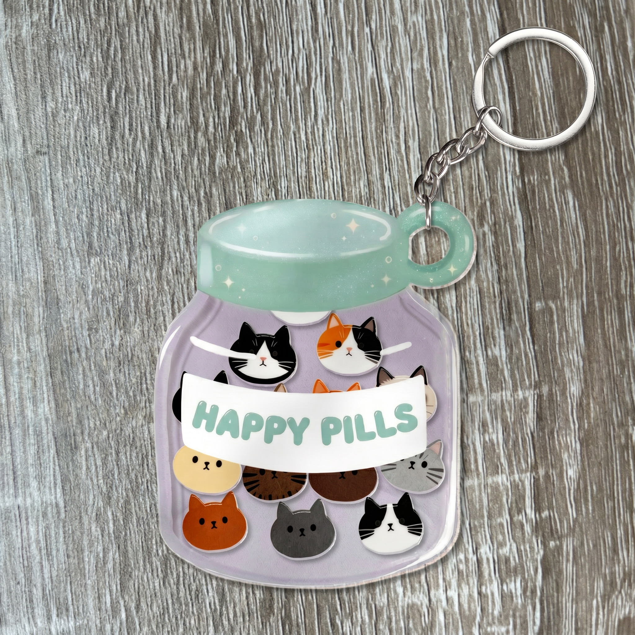 Keychain with cat illustrations and 'Happy Pills' text on a wooden surface