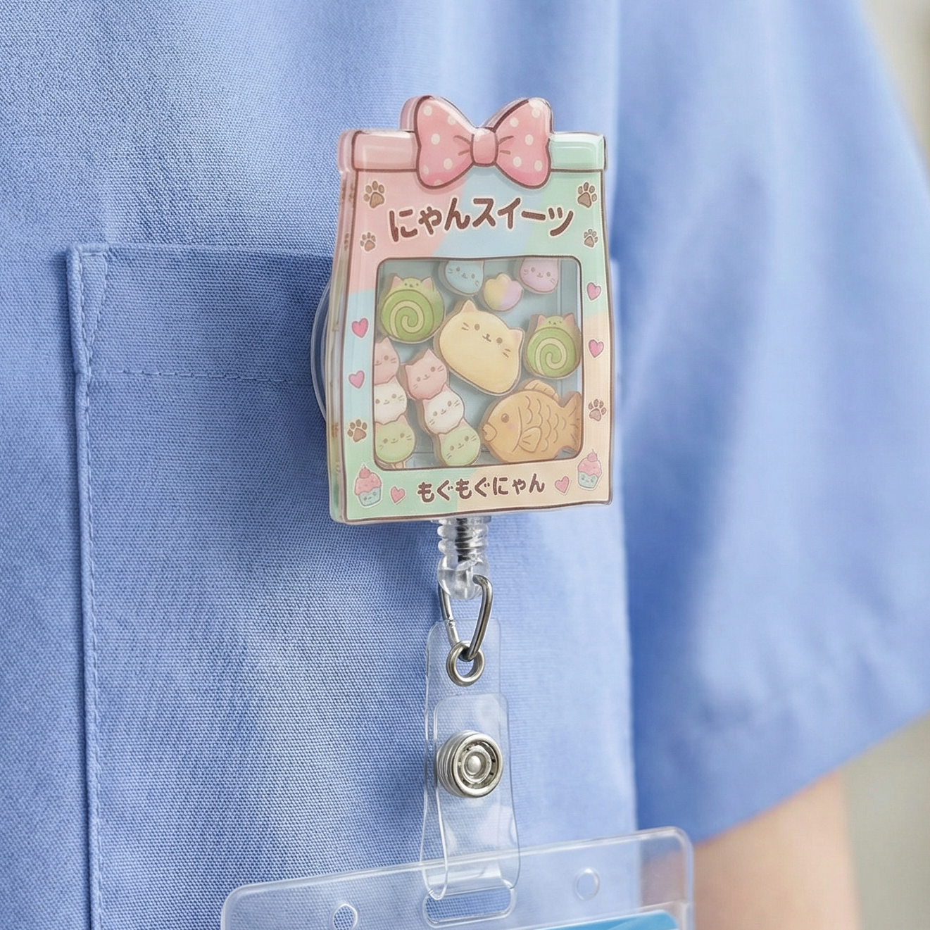 Person wearing a blue uniform with a cute kawaii cat bakery badge holder