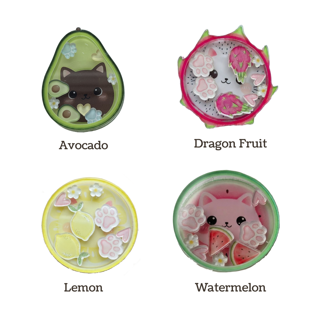 Four colorful acrylic shakers shaped like avocado, dragon fruit, lemon, and watermelon with animal designs on a white background.