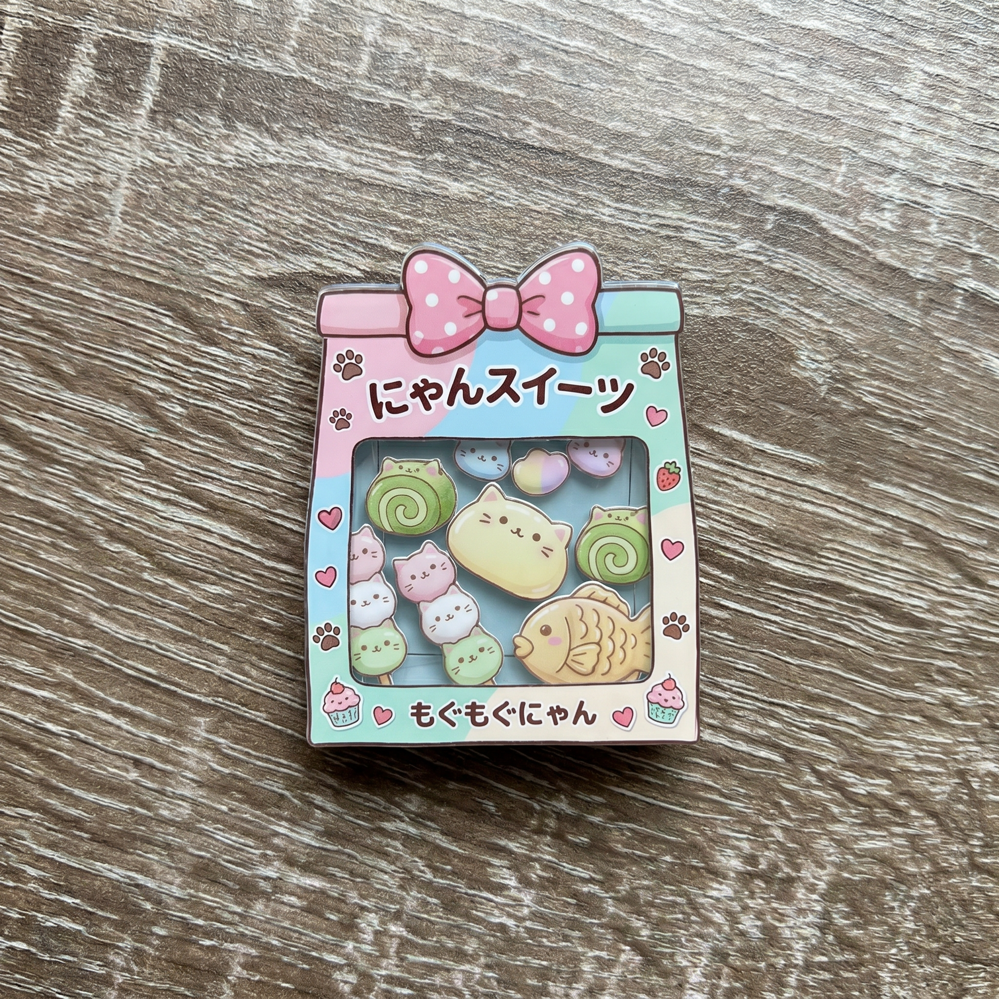 Cute shaker phone grip with kawaii Japanese cat pastries on a wooden surface