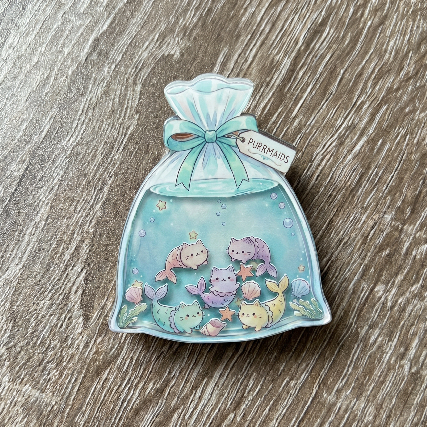 shaker phone grip goldfish bag with kawaii cat mermaids on a wooden surface