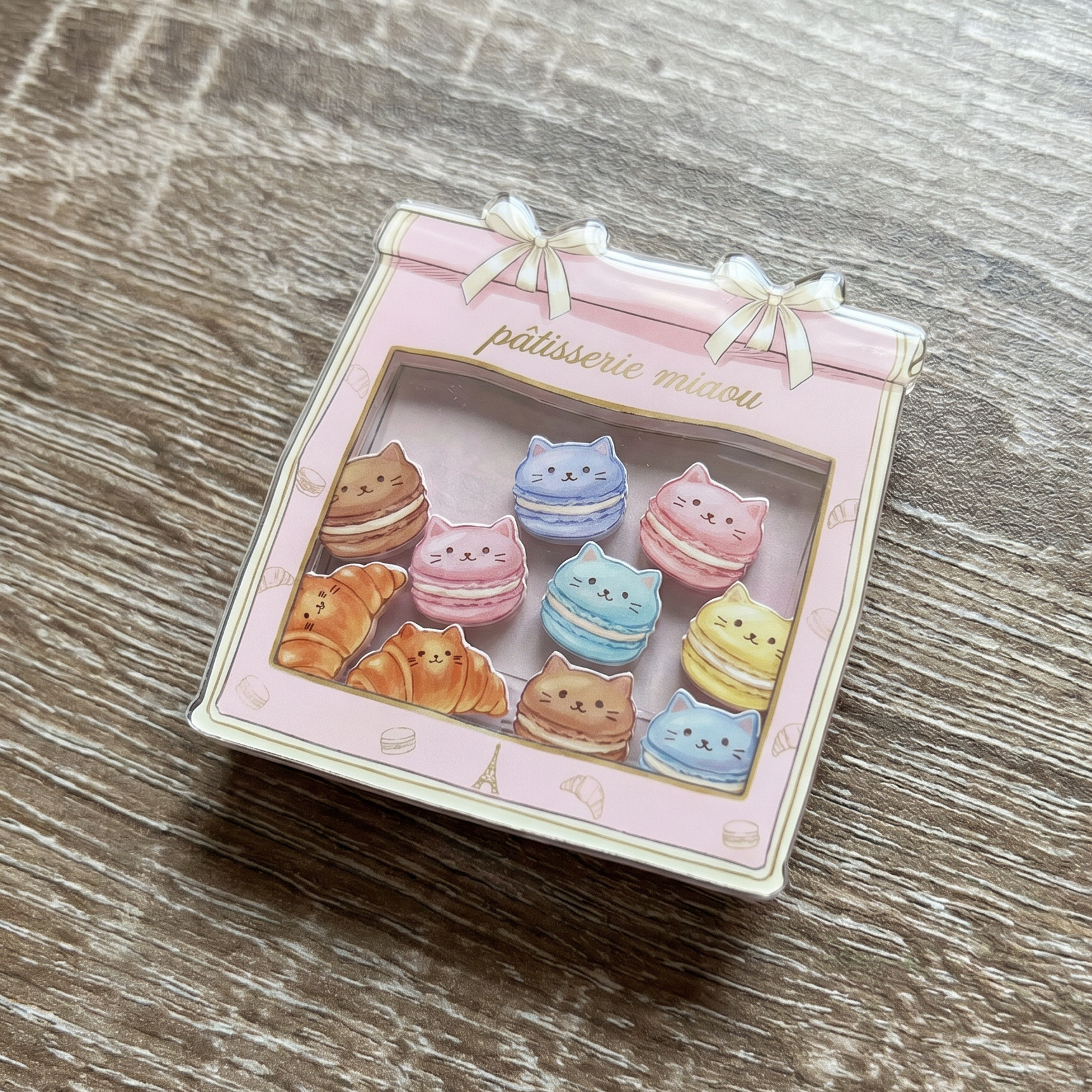 shaker phone grip of cat-shaped macarons on a wooden surface